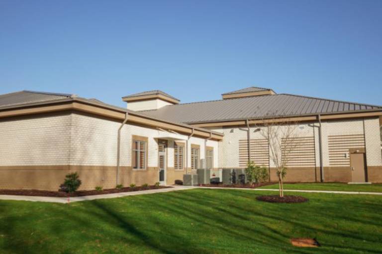 a building with a large lawn and a fence