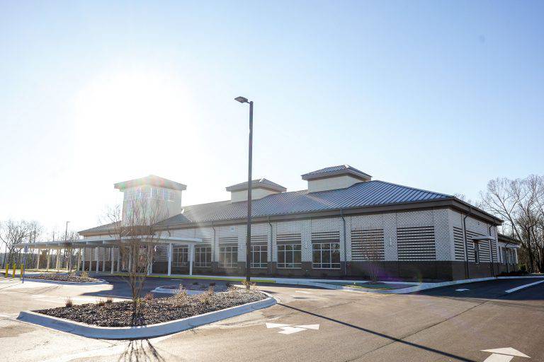 a building with a parking lot and sun