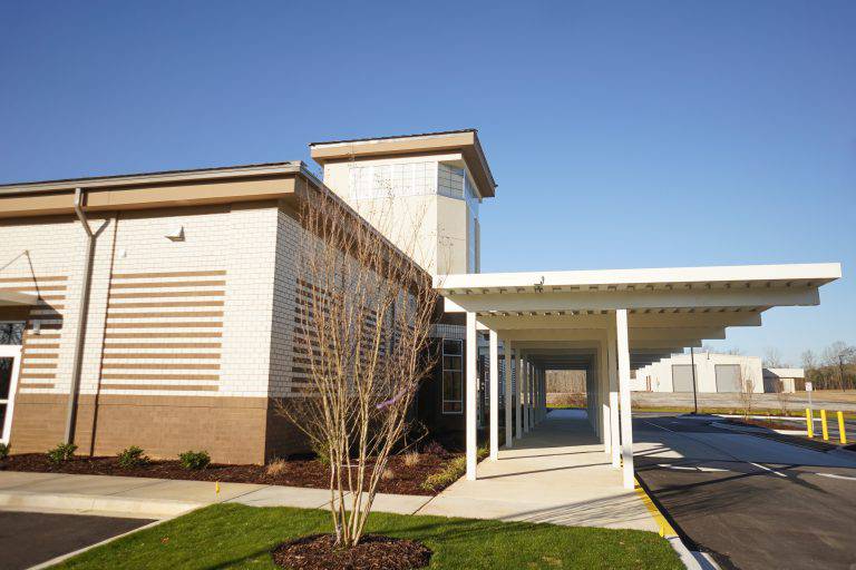 a building with a white roof and a parking lot
